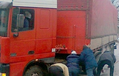 В Киеве огромный красный грузовик провалился под асфальт
