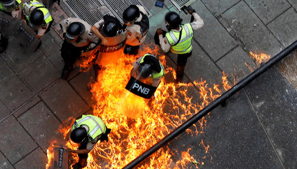 Полицейские загораются во время беспорядков