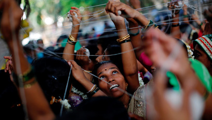 Индуистские женщины связывают хлопковые нитки вокруг дерева Баньяна