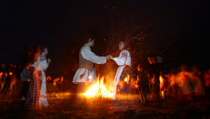 Люди танцуют у костра во время празднования Ивана Купалы 