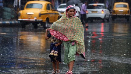 Мама прикрывает дочку от дождя