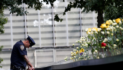 Полицейский стоит у мемориала погибшим