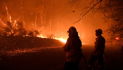 Бригады пожарной службы штата Новый Южный Уэльс в Австралии защищают имущество от сильного пожара.