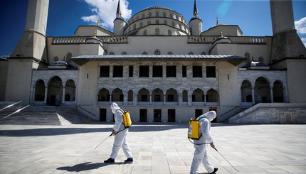 Муниципальные работники  в защитных костюмах дезинфицируют двор мечети Коджатепе