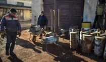 Робітники виготовляють дров'яні печі на фабриці у Львові.