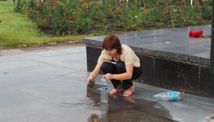 На центральной площади в Славянске женщина набирает воду для технических нужд.