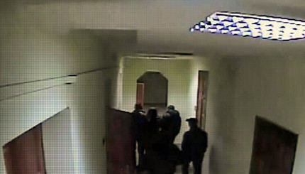 Подозреваемого выносят из здания облМВД после допроса