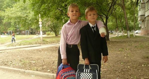 В Донецке хрупкие первоклашки тягают в школу портфели-