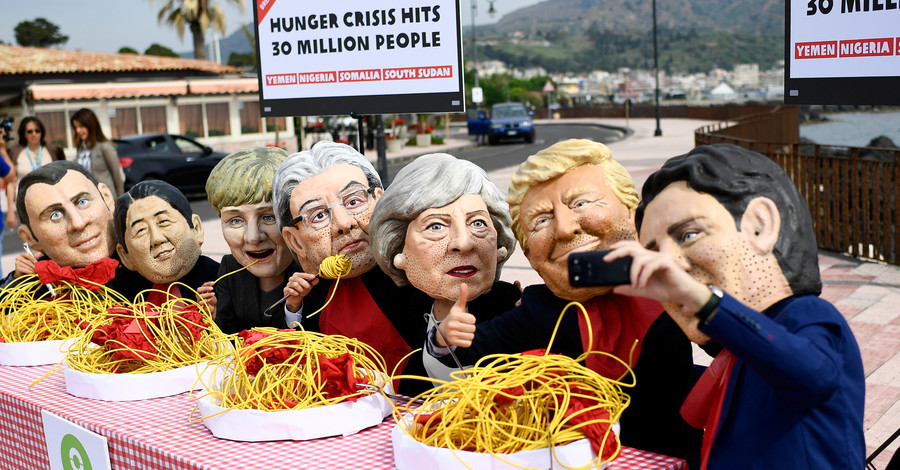 Протестующие в масках лидеров стран G7