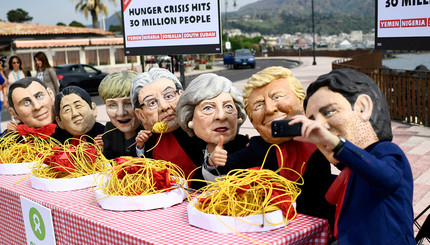 Протестующие в масках лидеров стран G7