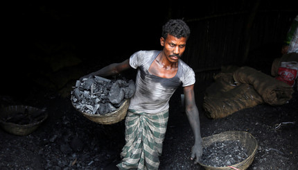 Работник несет уголь в корзине