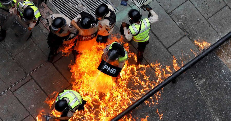 Полицейские загораются во время беспорядков