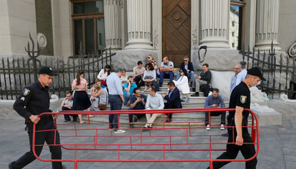 Полицейские несут барьер мимо украинских депутатов