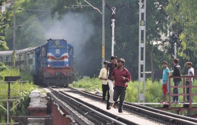 Индийские подростки развлекаются прыжками с моста перед приближающимся поездом 