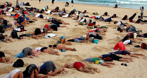 На пляже Австралии сотни людей сунули головы в песок