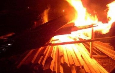 В Киеве жители Осокорков сломали забор стройки и подожгли стройматериалы