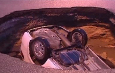 В Китае водитель сбежал из машины за секунду до падения в провал