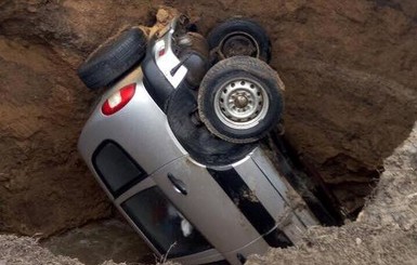 В Харькове внедорожник целиком ушел в огромную яму посреди дороги