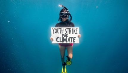 Маврикийский ученый и активист по борьбе с изменением климата Шаама Сандуйядержит плакат с надписью 