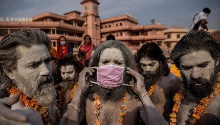 Нага Садху, или индуистские святые люди,надевают маски перед купанием в реке Ганг