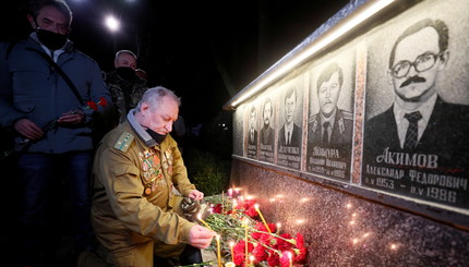 Мужчина зажигает свечу у мемориала, посвященного пожарным и рабочим, погибшим после аварии на Чернобыльской АЭС, в Славутиче, Ук