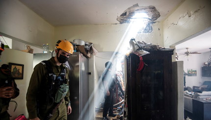 Солдаты находятся в здании, которое повреждено после того, как  военные группировки из сектора Газа выпустили более 300 ракет по