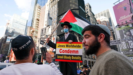 Пропалестинские ультраортодоксальные евреи протестуют против произраильского митинга на Таймс-сквер в Нью-Йорке.