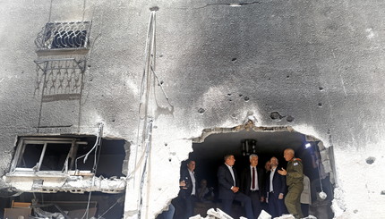 Министр иностранных дел Израиля Габи Ашкенази разговаривает c коллегами во время посещения здания, поврежденного ракетой, запуще