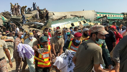 Солдаты и спасатели работают на месте происшествия после столкновения двух поездов в Готки, Пакистан.