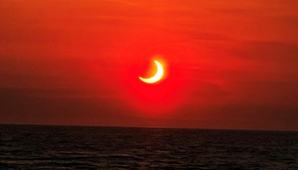 Частичное солнечное затмение видно над горизонтом в Эйвон-бай-зе-Си, штат Нью-Джерси, США