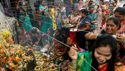 Замужние индуистские женщины возносят молитвы и обвязывают ниткой баньяновое дерево во время фестиваля Ват Пурнима в Мумбаи, Инд
