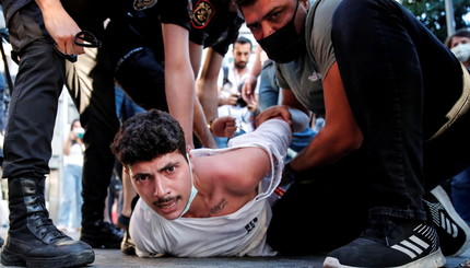 Полиция задерживает активиста во время акции протеста в годовщину взрыва бомбы, в результате которой погибли 34 человека в 2015 