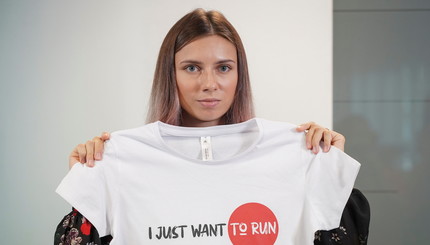 Белорусская спринтерка Кристина Тимановская, которая покинула Олимпийские игры в Токио и ищет убежища в Польше, держит футболку 