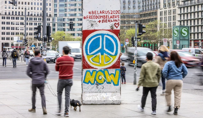 Берлинской стены с граффити символа мира цвета украинского флага