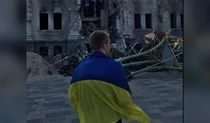У Маріуполі хлопець вийшов сфотографувався біля розбомбленого Драмтеатру з прапором України