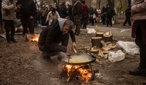 Волонтер готує на багатті в Херсоні