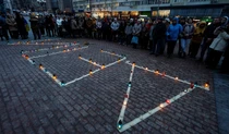 Люди почтили память жертв российского авиаудара по Мариупольскому драматическому театру