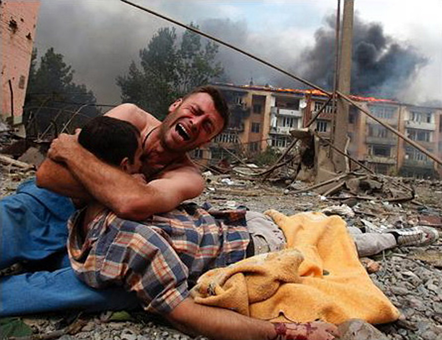 Ця фотографія чоловіка, який плаче над убитим під час російського бомбардування братом у місті Горі в 2008, облетіла весь світ. Але не змусила замислитись. Фото: Reuters_Гаранич/ka.wikipedia.org