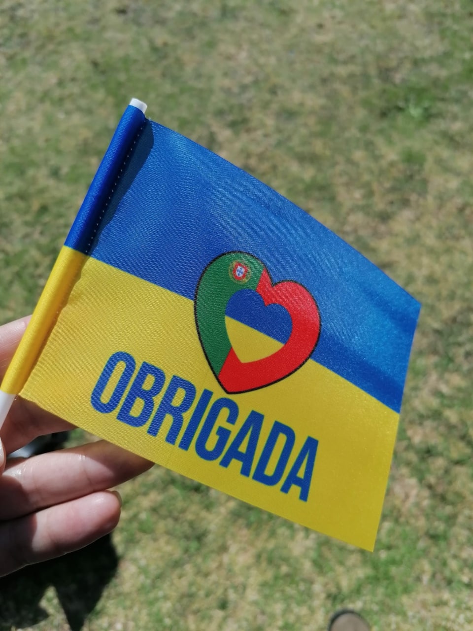Українці дякують португальцям синьо-жовтими прапорцями із серцем у кольорах португальського прапора та словом 