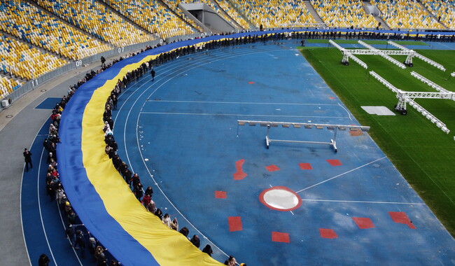 Жители Киева несут украинский национальный флаг на Олимпийском стадионе чтобы отметить День единства. Фото: REUTERS/Umit Bektas