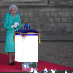 Британська королева Єлизавета II готується доторкнутися до глобуса Співдружності Націй, щоб розпочати запалення Головного маяка за межами Букінгемського палацу в Лондоні. Фото: Photo by Steve Parsons-Pool/Getty Images