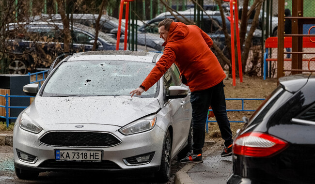 Чоловік перевіряє пошкоджену машину після російського ракетного удару по Києву. Фото: REUTERS/Gleb Garanich