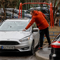 Чоловік перевіряє пошкоджену машину після російського ракетного удару по Києву. Фото: REUTERS/Gleb Garanich