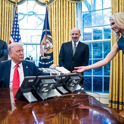 Среди избранных: Натали Харп передает президенту Дональду Трампу распечатку из принтера (как «человек-принтер»), рядом – министр здравоохранения Роберт Ф. Кеннеди-младший и министр торговли Говард Лютник, 25 февраля 2025 года. Фото: Jabin Botsford/The Washington Post via Getty Images